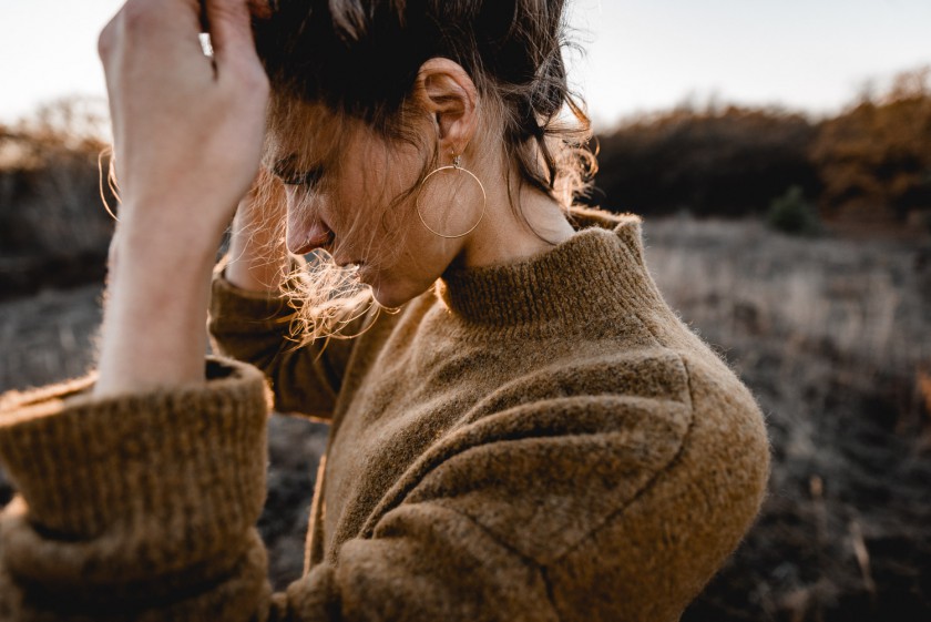 Frau im Wind bei Sonnenuntergang