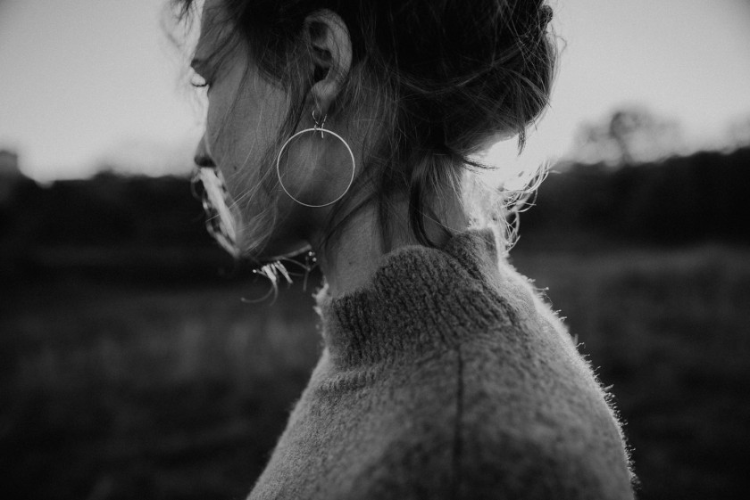 Frau im Wind während eines Sonnenuntergangs